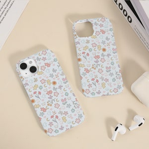 May include: Two light blue phone cases with a floral pattern. The pattern includes small flowers, hearts, stars, moons, and bears.
