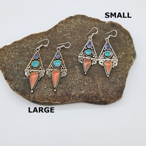 May include: Two pairs of earrings, one pair is labeled "SMALL" and the other pair is labeled "LARGE". Both pairs are silver with turquoise and blue stones and coral accents.