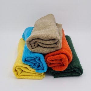 May include: A stack of four rolled fabric swatches in different colors: yellow, blue, orange, and green.