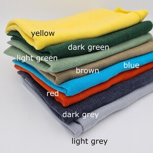 May include: A stack of fabric swatches in various colors, including yellow, dark green, light green, brown, blue, red, dark grey, and light grey.