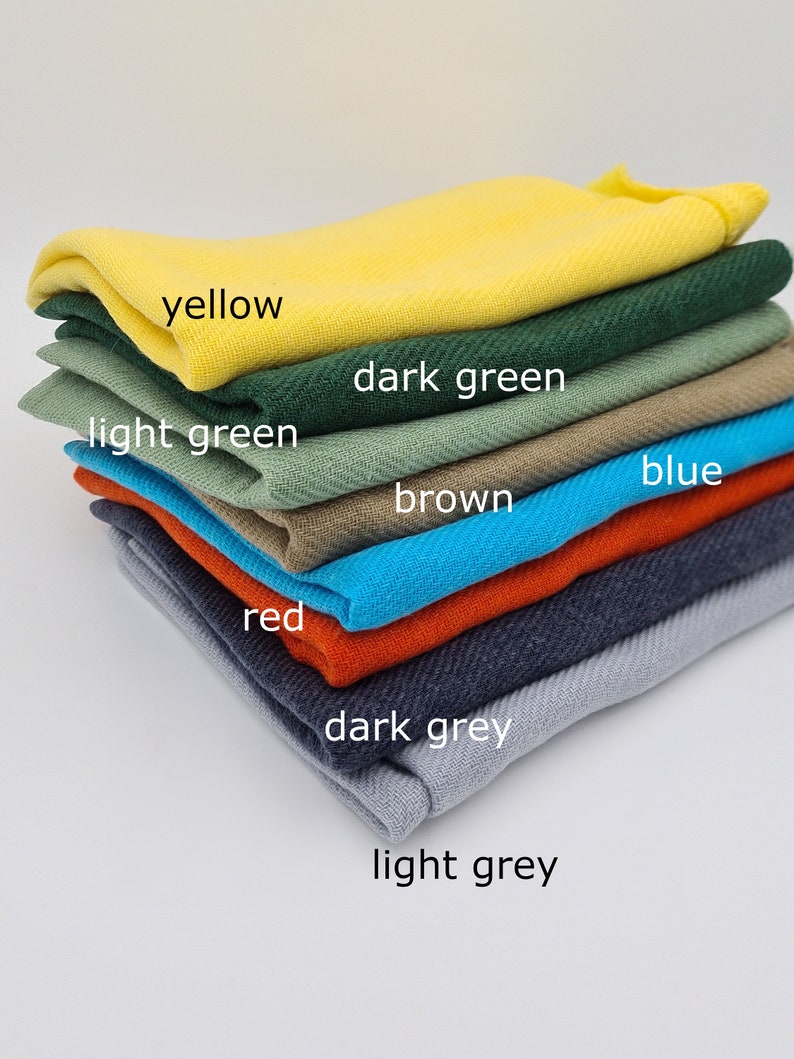 May include: A stack of fabric swatches in various colors, including yellow, dark green, light green, brown, blue, red, dark grey, and light grey.