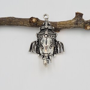 Op de afbeelding: Zilveren hangerbedel met een gedetailleerde afbeelding van de hindoe-godheid Ganesha, de olifantenkopgod van wijsheid en geluk.