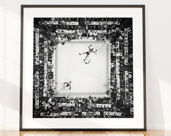 Puede incluir: Impresión en blanco y negro enmarcada de un combate de boxeo, vista desde arriba. Dos boxeadores están en el ring, rodeados de una multitud. La impresión se muestra en una pared blanca con un suelo de madera. El texto en la parte inferior dice "Blanco y negro y color incluido."