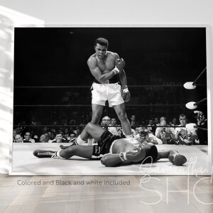 Puede incluir: Fotograf&iacute;a en blanco y negro de un combate de boxeo. Un boxeador se encuentra de pie sobre otro boxeador que est&aacute; tendido en el suelo. El boxeador de pie lleva pantalones cortos y guantes de boxeo. El boxeador que est&aacute; tendido en el suelo lleva pantalones cortos y guantes de boxeo. La foto se tom&oacute; en un ring de boxeo con una multitud de espectadores en el fondo.