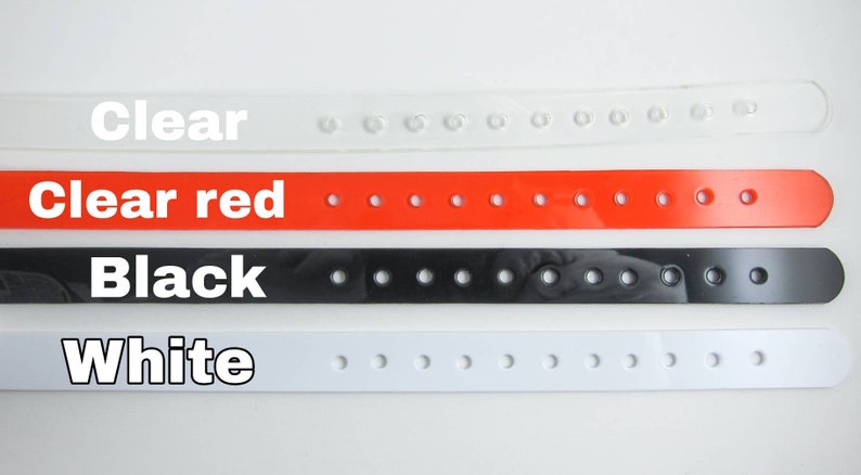May include: Four plastic wristbands in different colors: clear, clear red, black, and white. Each wristband has multiple holes for adjustment.