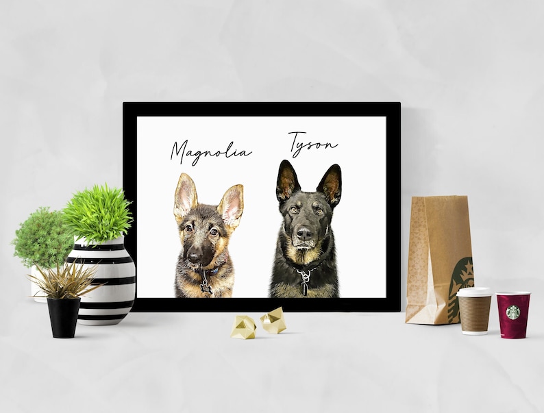 May include: A black framed print with two dog portraits. The dog on the left is a brown and black German Shepherd puppy with the name 'Magnolia' written above it. The dog on the right is a black German Shepherd with the name 'Tyson' written above it.