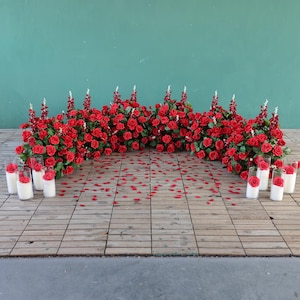 Arreglo floral de rosas rojas, blancas y hojas verdes para bodas.