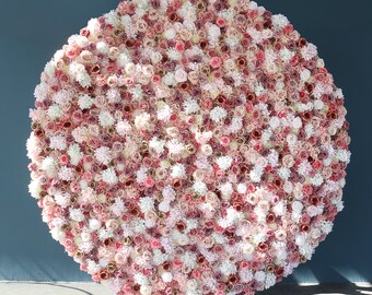 May include: A large round floral backdrop made of pink, white, and cream artificial flowers. The backdrop is perfect for weddings, parties, and other events.