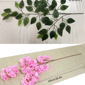 Pu&ograve; includere: Due rami di fiori artificiali con fiori rosa e foglie verdi. I rami sono lunghi 60 cm e 100 cm.