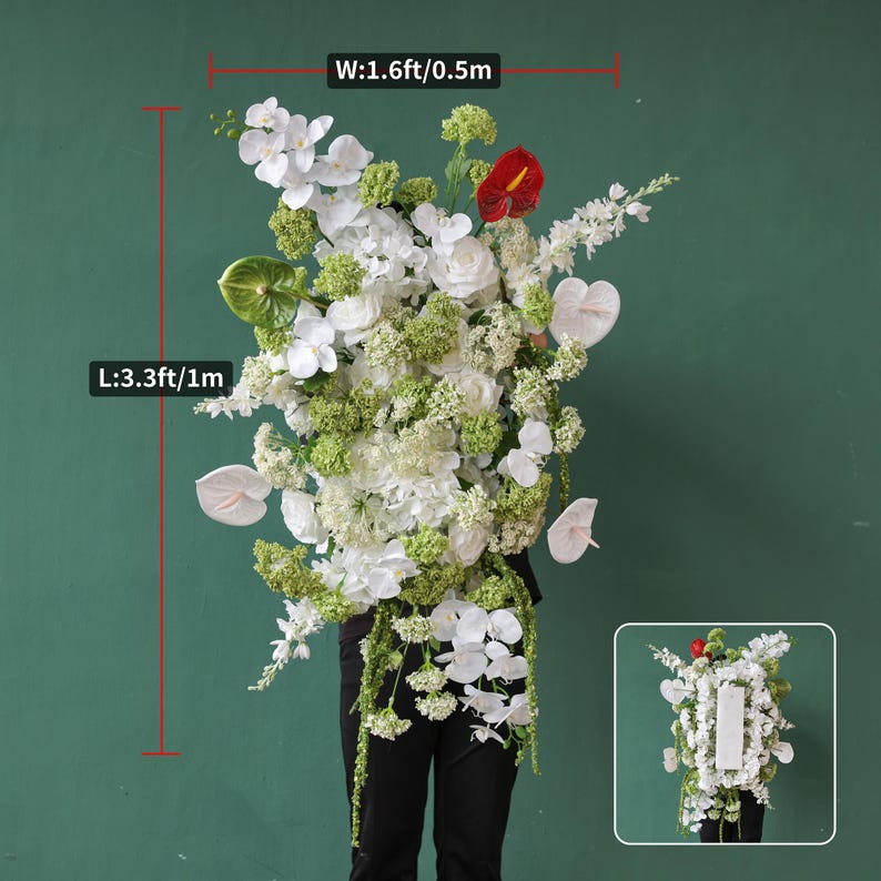 May include: A large floral arrangement featuring white orchids, roses, and anthuriums, accented with green foliage and a single red anthurium. The arrangement is approximately 3.3 feet (1 meter) tall and 1.6 feet (0.5 meters) wide.