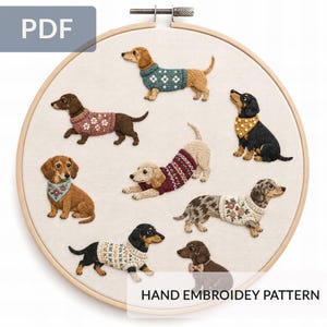 Könnte beinhalten: Ein runder Stickrahmen aus Holz mit einem Handstickmuster auf cremefarbenem Stoff. Das Design zeigt acht Dackel in verschiedenen Posen, die Pullover, Halstücher und eine Fliege mit floralen und geometrischen Mustern tragen.