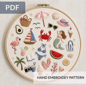 May include: A round wooden embroidery hoop containing a white fabric panel with various summer-themed embroidered motifs including a sailboat, a mermaid, a flamingo, a crab, a watermelon slice, a palm tree, a camera, and beach accessories.