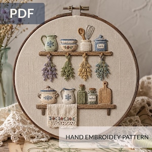 May include: A hand-embroidered kitchen scene in a wooden hoop. The design features shelves with miniature kitchenware, herbs, and a cutting board. The text "PDF" and "HAND EMBROIDERY PATTERN" are visible.