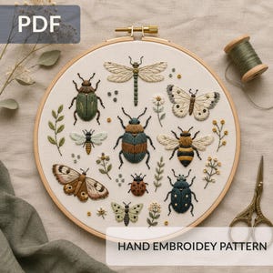 May include: A hand-embroidered design of insects, such as beetles, butterflies, and a dragonfly, in green, brown, and yellow hues. The embroidery is displayed in a wooden hoop, with the text "HAND EMBROIDERY PATTERN".