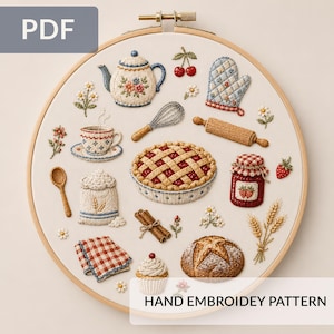 May include: A circular wooden embroidery hoop containing a white fabric panel with hand-stitched kitchen motifs including a teapot, pie, whisk, rolling pin, jam jar, cupcake, bread loaf, flour sack, and checkered cloth, with the text HAND EMBROIDERY PATTERN.