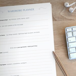 May include: A white sheet of paper with the title "Wardrobe Planner" printed at the top. The paper is divided into sections with headings such as "Season", "Desired look & feel", "Colors", "Iconic items", "Coats & Jackets", "Top layers", and "Write down your garments - what you'll buy".