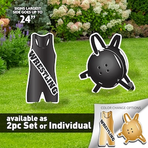 May include: Black and white wrestling singlet and headgear yard signs. The singlet has the word "WRESTLING" written diagonally across the front. The signs are available as a 2-piece set or individually. Color change options are available in gold.
