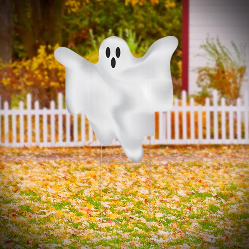 Pu&ograve; includere: Una decorazione da giardino a forma di fantasma bianco con un viso amichevole. Il fantasma &egrave; in piedi in un giardino con foglie cadute.
