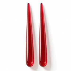May include: Two elongated, tapered glass objects in a vibrant, translucent red color. Each piece features a smooth, rounded base that gradually narrows to a pointed tip, creating a sleek, symmetrical, and minimalist form with a glossy finish.