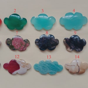 May include: Fifteen cloud-shaped cabochons in various colors and patterns, including red, green, blue, brown, white, and black. The cabochons are numbered 1 through 15.