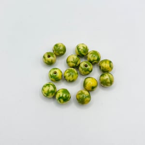 May include: A group of 14 round ceramic beads with a yellow base and green leaf pattern.