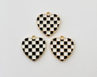May include: Three gold heart-shaped charms with a black and white checkered pattern.