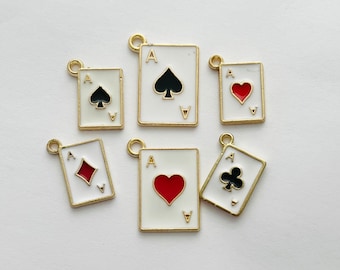 May include: Six gold-colored metal charms shaped like playing cards. Each charm features a different suit: spades, hearts, diamonds, and clubs. The charms are all white with black or red accents.
