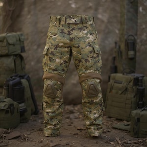 May include: Camouflage cargo pants with knee pads. The pants feature a digital camouflage pattern in shades of green, brown, and tan. The knee pads are a solid brown color. The pants have multiple pockets.