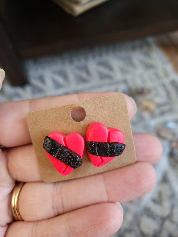 Mended heart, pink and black polymer clay stud earrings.