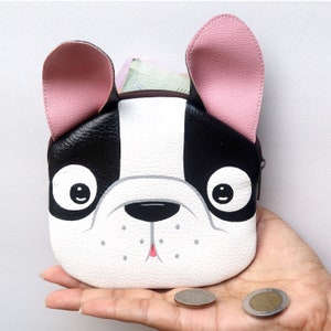 K&ouml;nnte beinhalten: Eine kleine schwarze und wei&szlig;e Geldb&ouml;rse in Form einer franz&ouml;sischen Bulldogge mit rosa Ohren. Die B&ouml;rse ist aus Kunstleder und hat einen Rei&szlig;verschluss.