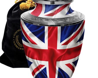 May include: Silver cremation urn with a Union Jack flag design. The urn has a silver lid and a black velvet bag.