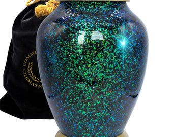 May include: A green and black cremation urn with a gold lid and base. The urn has a speckled, iridescent finish.