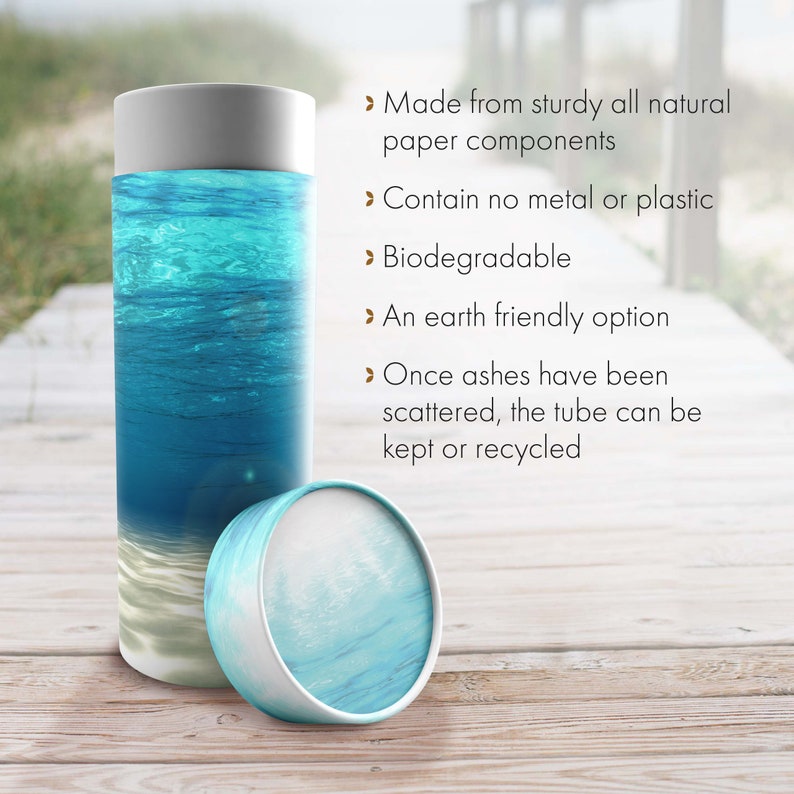 May include: A biodegradable cremation urn made from natural paper components. The urn features a blue and white ocean scene and is designed to be scattered in water. The text on the image reads: "Made from sturdy all natural paper components", "Contain no metal or plastic", "Biodegradable", "An earth friendly option", "Once ashes have been scattered, the tube can be kept or recycled".