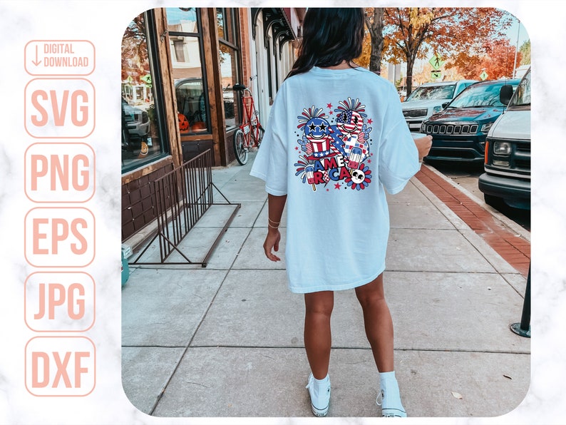 May include: A light blue t-shirt with a colorful graphic design featuring fireworks, stars, and the word "America".