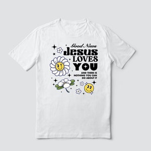 May include: White t-shirt with a graphic design featuring a daisy, a smiley face, and the text "Good News Jesus Loves You" and "And there is nothing you can do about it".