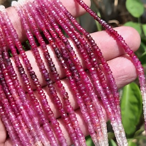 May include: Strands of faceted ruby beads in varying shades of pink and red. The beads transition from a pale pink to a deep ruby color. The beads are strung together, creating a delicate and elegant appearance.