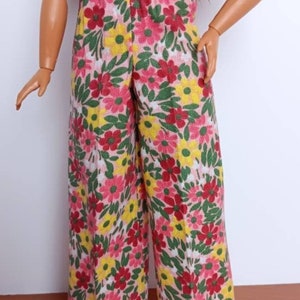 May include: Wide-legged pants with a floral print featuring pink, red, yellow, and green flowers on a white background.