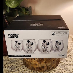 Puede incluir: Un juego de cuatro vasos de Mickey Mouse de edici&oacute;n limitada en una caja. Cada vaso transparente presenta una ilustraci&oacute;n en blanco y negro de Mickey Mouse. La caja es negra y tiene el logotipo de Disney Mickey Mouse y la marca Joyjolt.