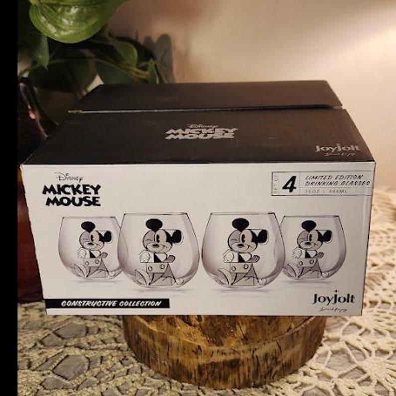 Puede incluir: Un juego de cuatro vasos de Mickey Mouse de edici&oacute;n limitada en una caja. Cada vaso transparente presenta una ilustraci&oacute;n en blanco y negro de Mickey Mouse. La caja es negra y tiene el logotipo de Disney Mickey Mouse y la marca Joyjolt.