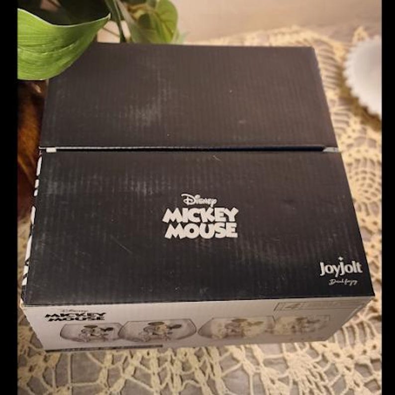 Puede incluir: Una caja negra con el logotipo de Disney Mickey Mouse en blanco. La caja est&aacute; hecha de cart&oacute;n corrugado y tiene un logotipo de Joyjolt en el lateral. La caja contiene un juego de platos con el tema de Mickey Mouse.