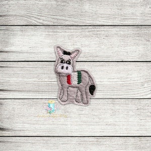 May include: A gray felt donkey with a black tail and a red, white, and green stripe on its back.