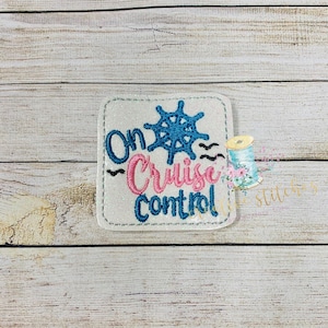 May include: White glitter patch with blue and pink embroidery. The patch says "On Cruise Control" with a blue ship's wheel in the center.