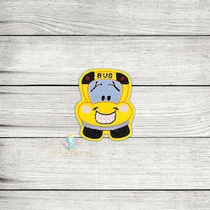 Könnte beinhalten: Ein gelber Schulbus mit einem lächelnden Gesicht und dem Wort "BUS" auf der Vorderseite. Der Bus hat schwarze Räder und eine blaue Windschutzscheibe.