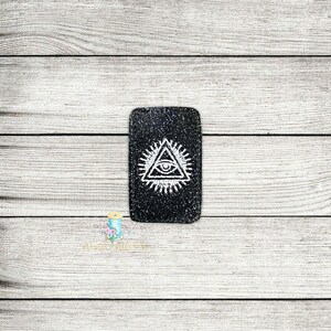 May include: Black and white rectangular patch with a white all-seeing eye design inside a triangle. The eye is surrounded by a circle of rays.