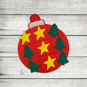 Peut inclure: Une décoration de Noël en feutre rouge avec un motif de jeu de morpion. Le plateau comporte neuf cases avec des étoiles jaunes et des sapins verts. L'ornement est parfait pour une activité de bricolage de Noël.