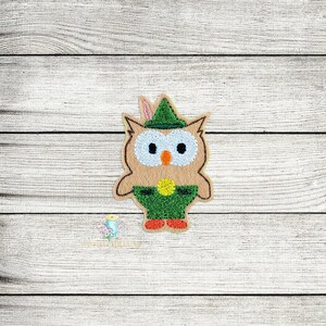 May include: A brown owl wearing a green hat with a feather, green pants, and yellow shoes. The owl has large blue eyes and an orange beak.