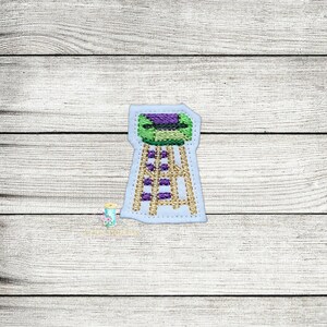May include: An embroidered stool with a green and purple design on a white background. The stool has a wooden frame and purple rungs.