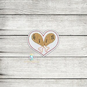 May include: White heart-shaped patch with two brown chicken drumsticks stitched inside. The drumsticks are crossed at the top and have a red outline.