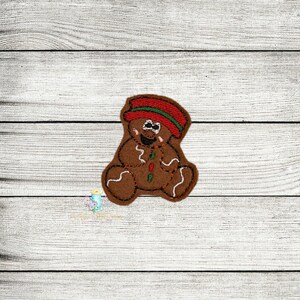 May include: A gingerbread man wearing a red and green hat, with a white icing smile and brown icing eyes. The gingerbread man is holding a candy cane in its hands.