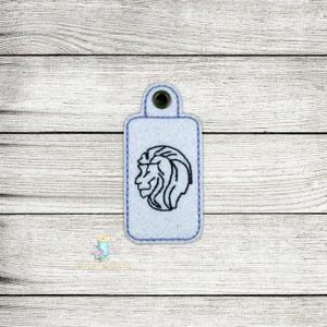 May include: A blue key chain with a black embroidered lion head design.